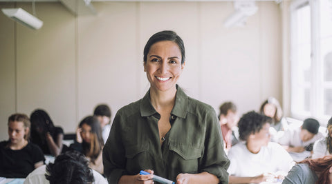 Professora numa sala de aula em frente aos seus alunos