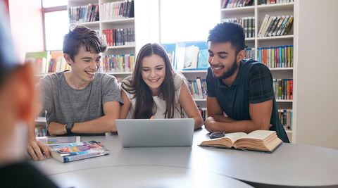 Três jovens adultos a explorar a intelgiência artificial no computador enquanto se divertem