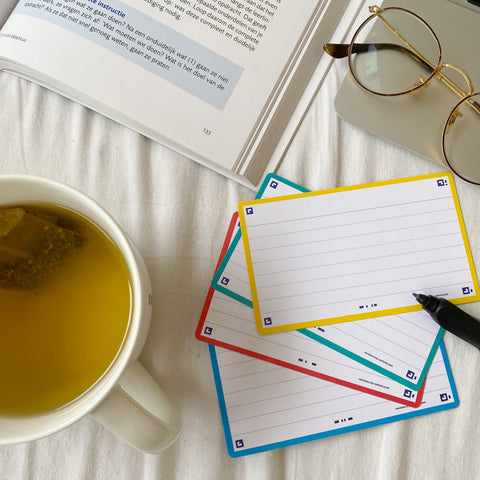 Flashcards da Oxford prontos para serem utilizados no estudo, rodeados por uns óculos, livro e chá.