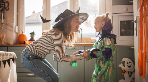 Mãe e filha a divertirem-se em casa com disfarces e decorações de Halloween
