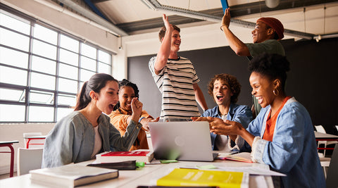 Estudantes a sorrir e dar high-five depois de uma resposta certa ao quiz 