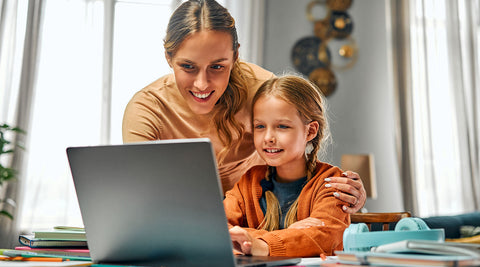 Mãe a ajudar a filha a estudar no computador
