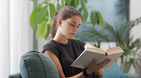 Jovem adulta a relaxar enquanto lê um livro
