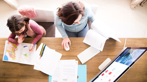 Mãe a ajudar o filho a estudar em casa com um computador, num momento de apoio ao estudo