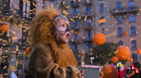 Menina disfarçada de leão com expressão de surpresa durante desfile de Carnaval