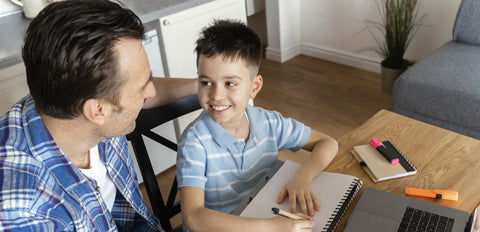 Pai a ajudar o filho que está no 1º ciclo a estudar